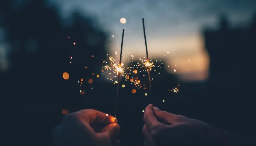 Mani che accendono scintille al tramonto, un modo magico per festeggiare, come si dice capodanno in inglese?