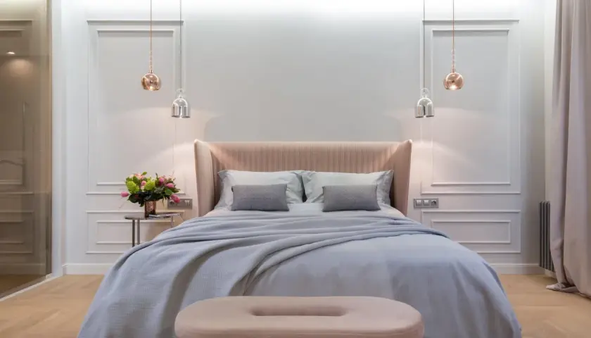 Achieve that hotel bed at home feeling with this plush, inviting bedroom setup. Soft linens, a cozy throw, and elegant lighting create a serene sanctuary.