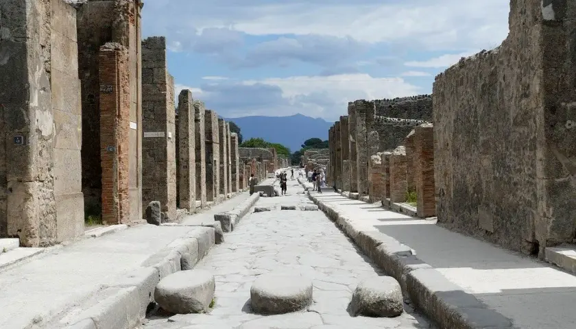 Ruines de Pompéi, une ancienne voie romaine menant vers le Vésuve. Un voyage de Rome à Pompéi est une immersion dans l'histoire.