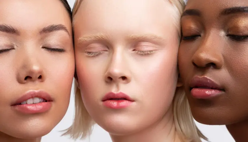 Trois visages aux teints variés, aux yeux clos, sublimés par un maquillage discret et naturel.