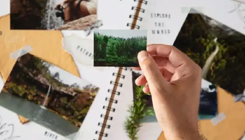 Creando un álbum de recuerdos con manualidades con fotos impresas. Un álbum de recortes con fotos de naturaleza y un paisaje forestal.