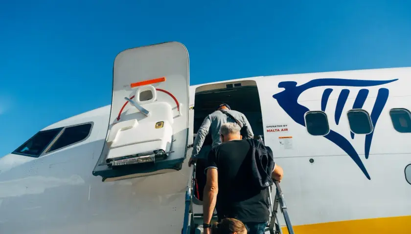 Ludzie wsiadają do samolotu Ryanair. Płatność przelewem za bilety była prosta, teraz czas na podróż!