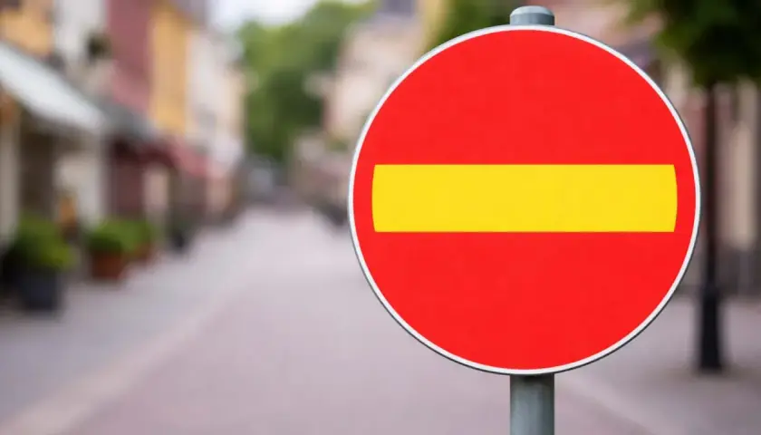 En röd cirkel med ett gult streck i mitten. En stoppskylt som signalerar stopp.