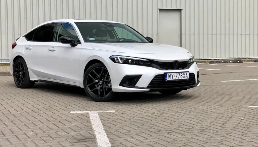 Biały Honda Civic 2025 z czarnymi felgami stoi na parkingu.