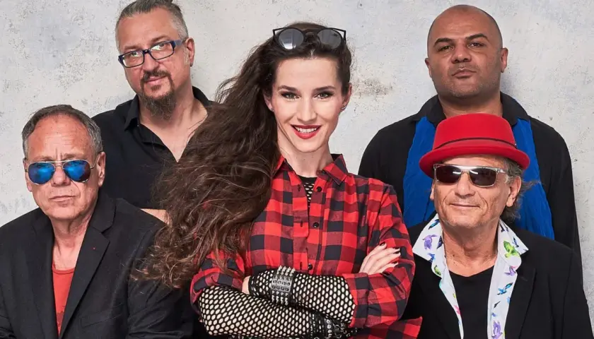 Zespół Maanam w nowym składzie: wokalistka w kratę, gitarzysta w czerwonym kapeluszu i reszta ekipy gotowa na scenę.