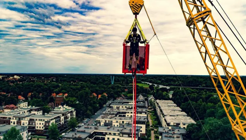 Ostatnie przygotowania przed skokiem bungee we Wrocławiu. Mężczyzna w koszu dźwigu, gotowy na adrenalinę.