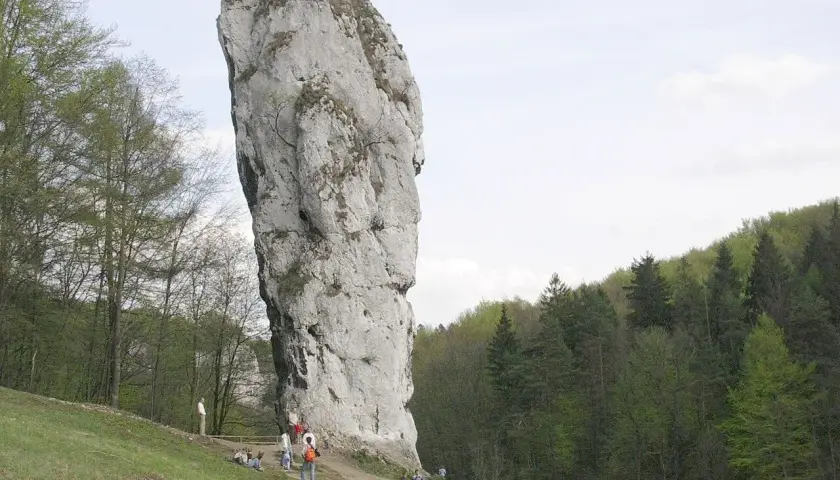 Wielka wapienna skała w parku narodowym, idealne miejsce na spacer z psem. Ludzie podziwiają krajobraz.