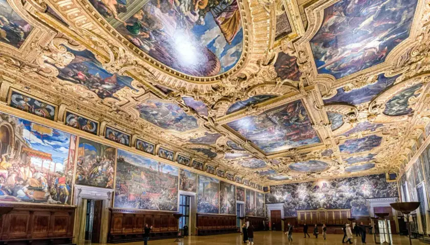 Intérieur grandiose du palais des Doges, plafonds peints et dorés racontant l'histoire de Venise. Des fresques monumentales ornent les murs et le plafond, témoins de la splendeur passée.
