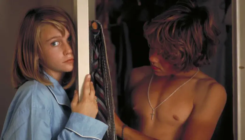 Ann-Sofie Kylin i blå pyjamas tittar mot en pojke med halsband.