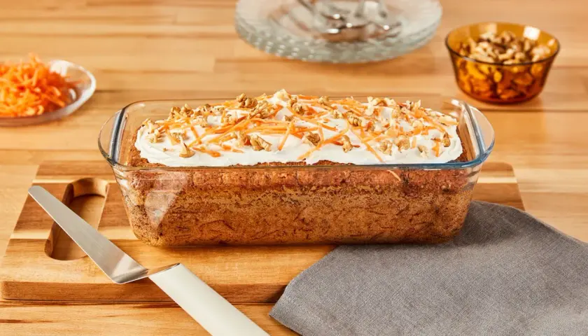 Gâteau aux carottes dans un plat en verre, garni de glaçage, carottes râpées et noix. Est-ce que le verre va au four ? Oui, ce plat en verre est conçu pour la cuisson.