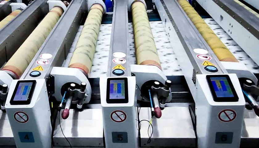 Lignes de machines industrielles pour l'impression rotative, avec des rouleaux et des écrans tactiles.