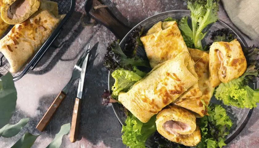 Herzhafte Pfannkuchen mit Schinken gefüllt, serviert mit Salat. Ein Genuss für jeden Gaumen!
