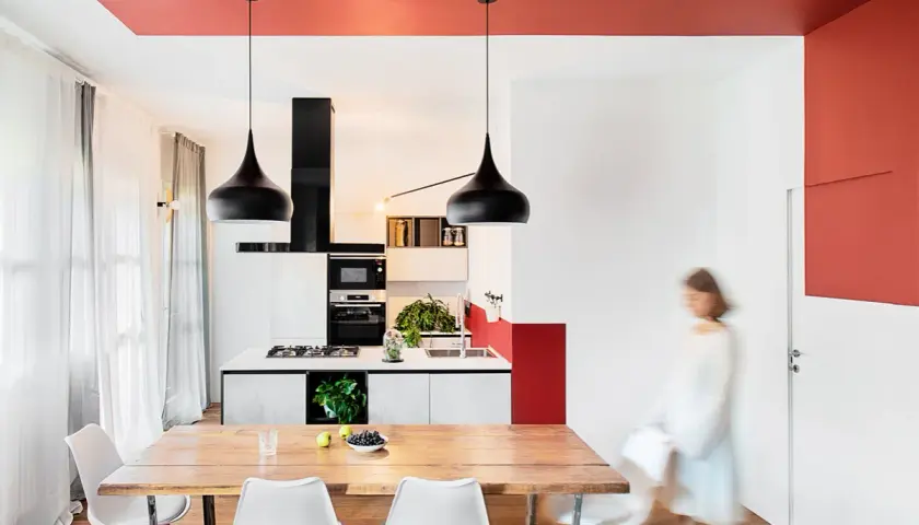 Soffitto rosso acceso per un tocco audace, un'idea pittura soffitto che valorizza la cucina moderna con lampade nere e arredi minimalisti.