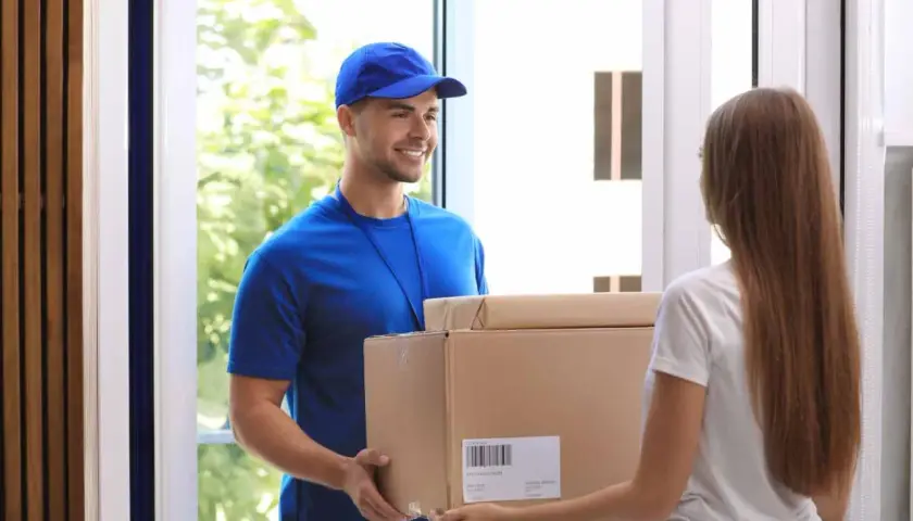 Lieferbote übergibt Frau ein Paket. Sie hofft, dass es nicht die **nicht bestellte Ware** ist, die sie schon einmal erhalten hat.