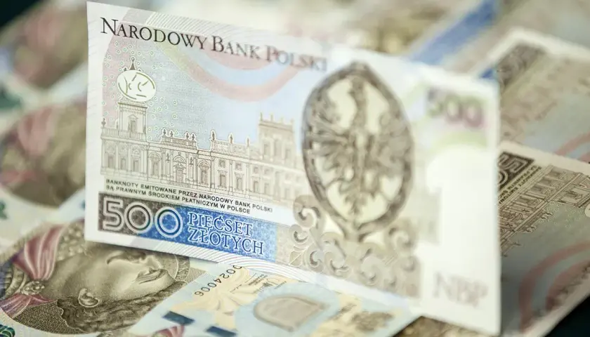 Stos banknotów 500 zł. Widoczny fragment z budynkiem i orłem.