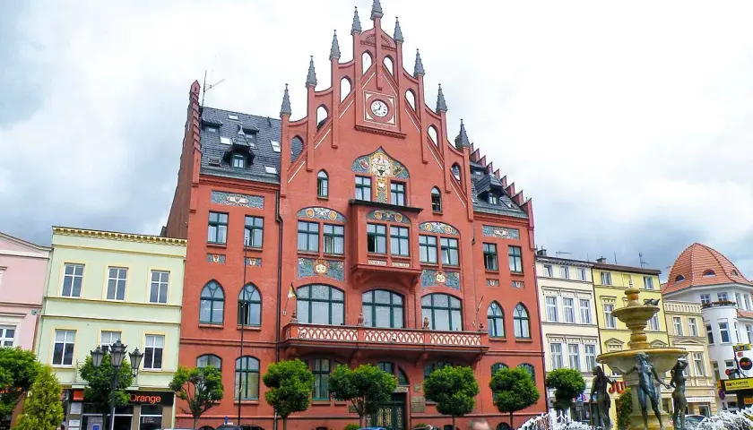 Rynek w Chojnicach z ratuszem i fontanną. Atrakcje miasta przyciągają turystów.