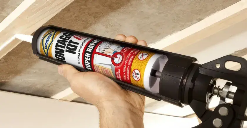 Applicazione di colla per cartongesso antiumido su listelli di legno per un montaggio rapido e sicuro.