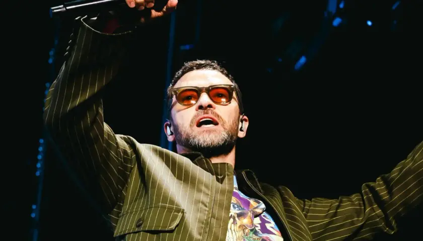 Justin Timberlake w okularach i marynarce w paski śpiewa na koncercie w Polsce.