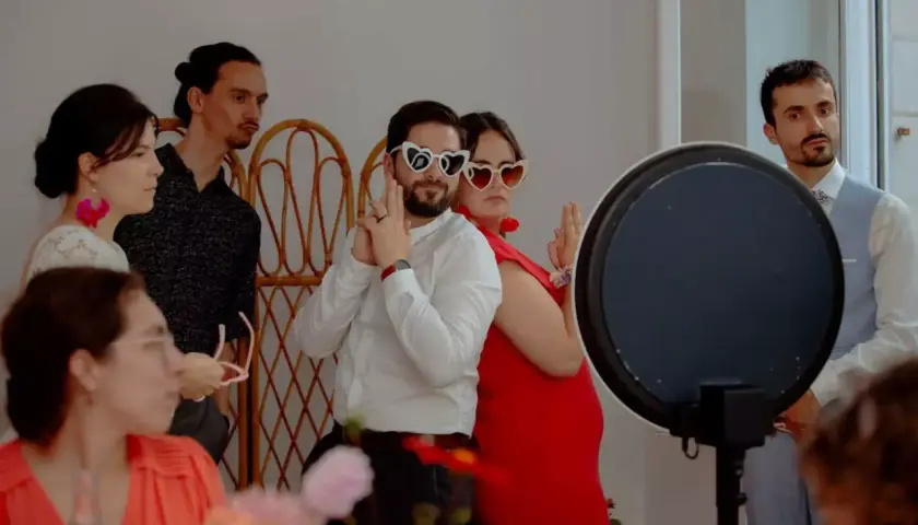 Des invités s'amusent avec des lunettes en forme de cœur lors d'un repas enfant mariage.