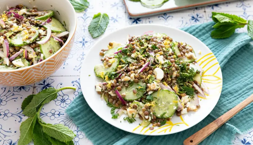 Salade de lentilles, concombre, oignon rouge et feta émiettée, garnie d'herbes fraîches. Un délice léger et savoureux.