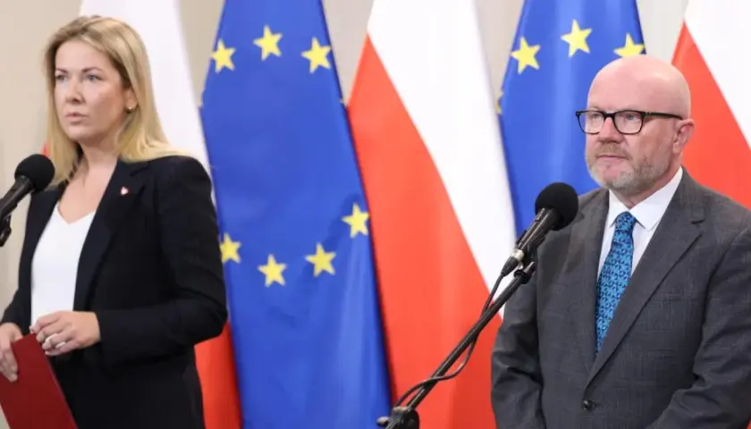 Kobieta i mężczyzna przed mikrofonami na tle flag Polski i UE. Czy ustawa o "teście na polaka" ma szansę przejść przez sejm w marcu?