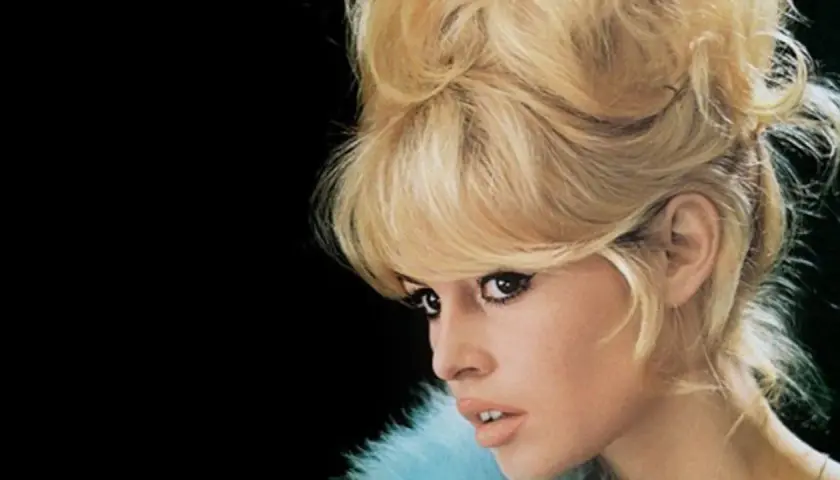 Icono de los moda peinados de los 60 con cabello rubio voluminoso y maquillaje dramático.