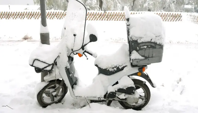 Moto cubierta de nieve, lista para no arrancar en frío.