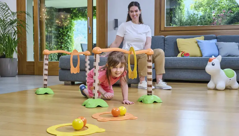Bambina di 5 mesi esplora un percorso giochi con la mamma. Attività divertente e stimolante per lo sviluppo motorio.