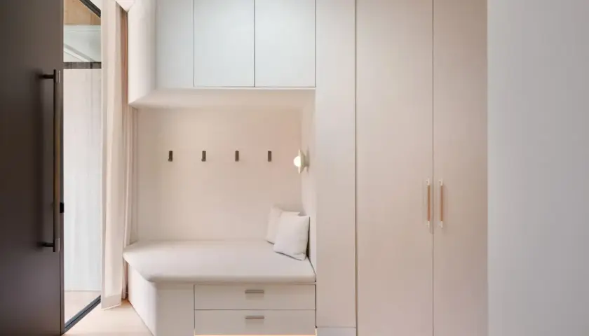 Coin salon moderne avec banquette intégrée, rangements et armoire murale. Le **pose lambris** discret souligne l'espace cosy.