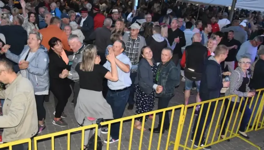 Tłum ludzi bawi się na ostrzyce koncert, tańcząc i świętując.