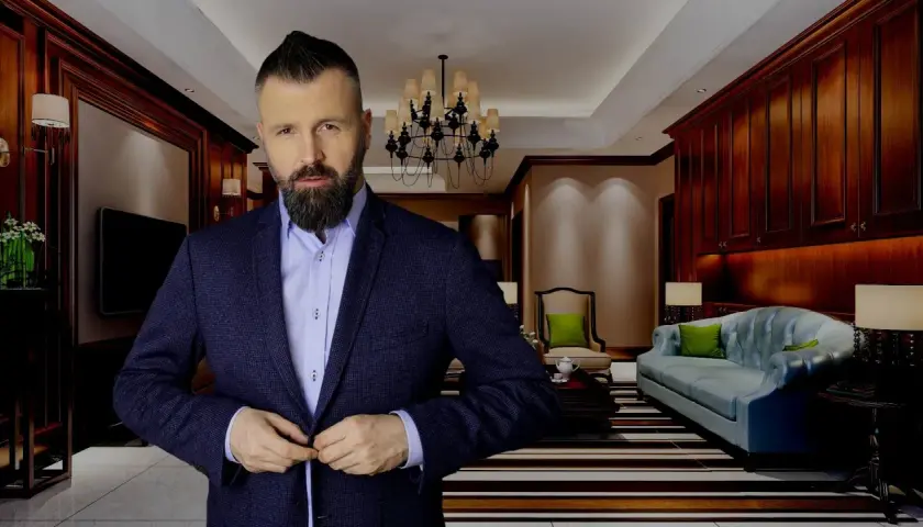 Mężczyzna w garniturze zapina marynarkę w eleganckim salonie.