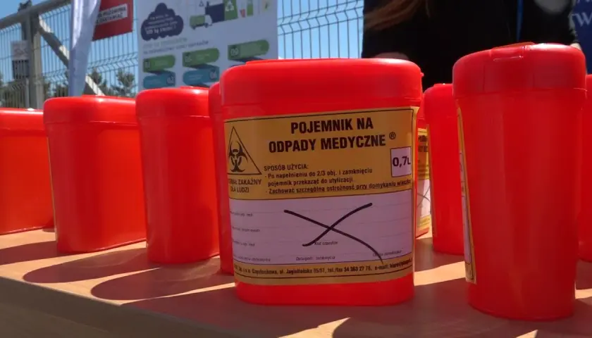 Czerwone pojemniki na odpady medyczne, w tym zużyte igły, czekają na prawidłowe wyrzucenie.