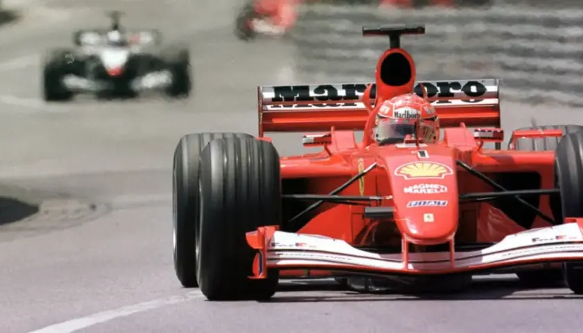 Ein roter Ferrari-Rennwagen rast auf der Strecke. Man fragt sich, was kostet ein Formel 1 Auto, wenn es so schnell ist?