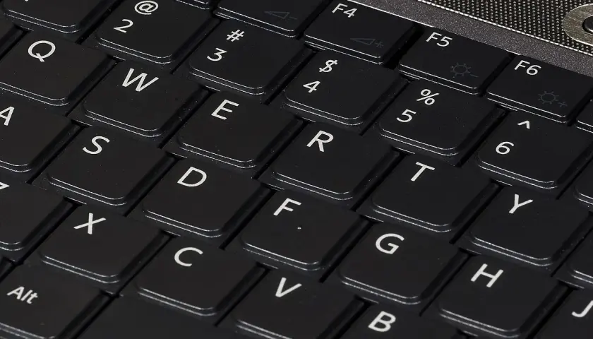 Zbliżenie na klawiaturę laptopa z widocznymi klawiszami QWERTY. Różne rodzaje klawiatur w telefonie mogą przypominać ten układ.