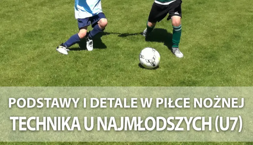 Dwóch młodych piłkarzy ćwiczy podanie w piłce nożnej na zielonej murawie.