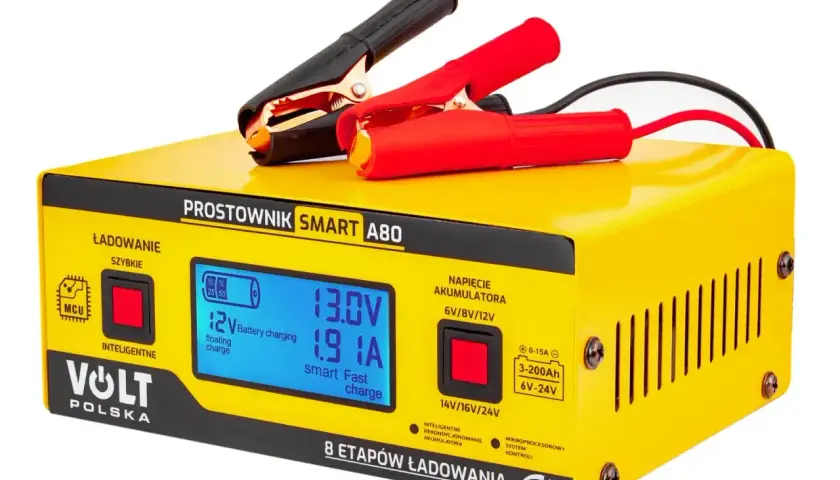Żółty prostownik Volt Polska Smart A80 z wyświetlaczem LCD, gotowy do ładowania akumulatora. Czerwone i czarne kable z zaciskami.