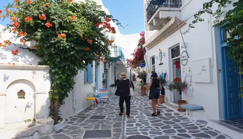 Ein malerischer Gang auf der Insel Paros, Griechenland, mit blühenden Bougainvillea und weiß getünchten Häusern.