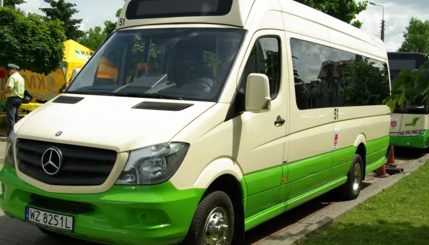 Biało-zielony bus Mercedes-Benz z numerem 51 na dachu, zaparkowany na zewnątrz.