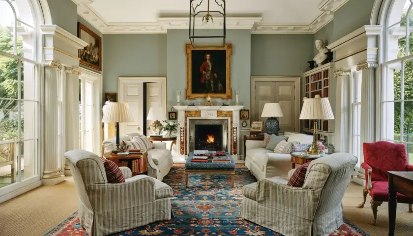 Elegant living room with fireplace, portraits, and plush seating, showcasing the expertise of home design consultants.