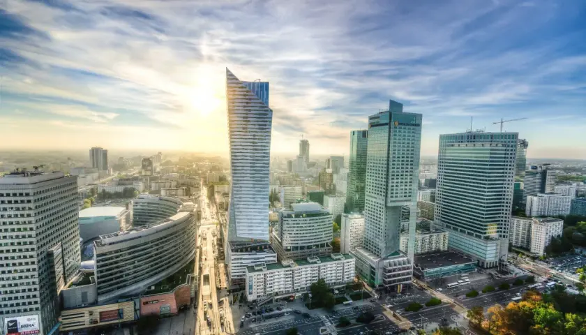 Widok na nowoczesne centrum Warszawy o zachodzie słońca. Marzenie o studiach w Warszawie staje się rzeczywistością wśród tych drapaczy chmur.