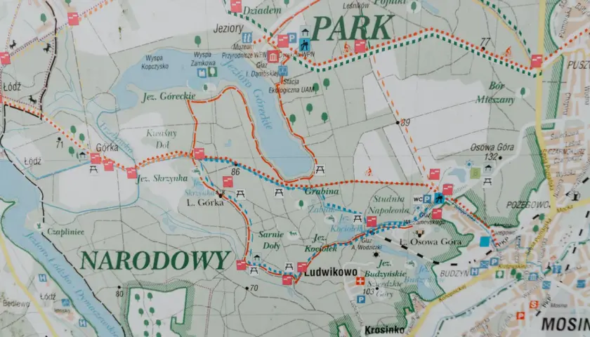 Mapa Wielkopolskiego Parku Narodowego z zaznaczonymi jeziorami, szlakami i ciekawostkami, jak Jezioro Góreckie czy Studnia Napoleona.