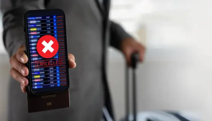 Telefon z napisem "CANCELLED" i czerwonym krzyżykiem, pod nim paszport. Podróż z Ryanair zwrot biletu stał się niemożliwy.