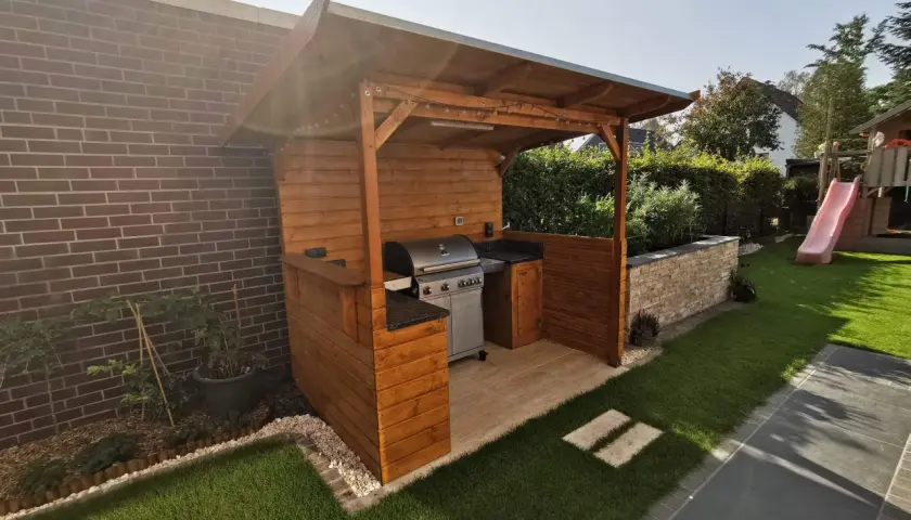 Ein schöner Grillunterstand, den man selber bauen kann, mit Grill, Arbeitsfläche und Beleuchtung.