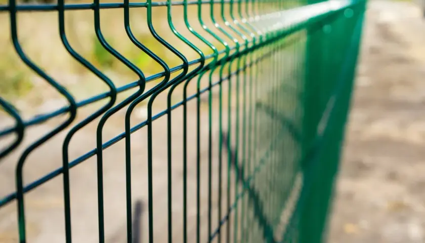 Zielona siatka ogrodzeniowa. Jeśli zastanawiasz się, gdzie zgłosić nielegalne ogrodzenie, sprawdź lokalne przepisy.