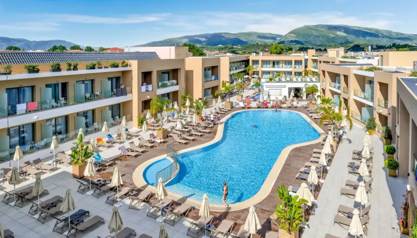 Luksusowy hotel White Olive Elite w Laganas, Grecja. Basen, leżaki i palmy tworzą idealne miejsce na relaks.