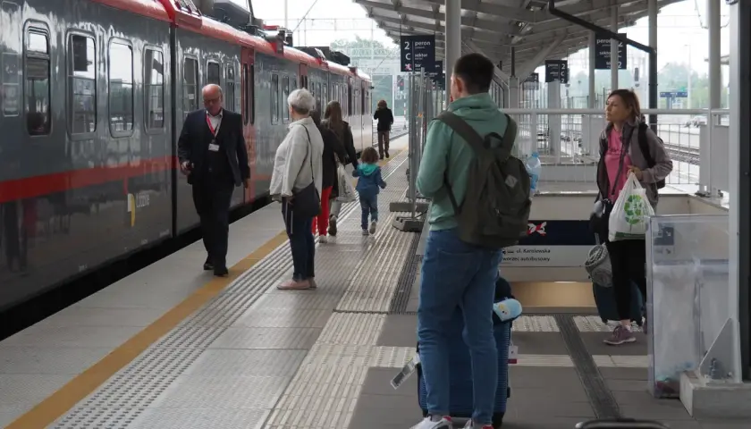 Ludzie na peronie czekają na pociąg. Zastanawiasz się, ile zarabia kierowca pociągu?