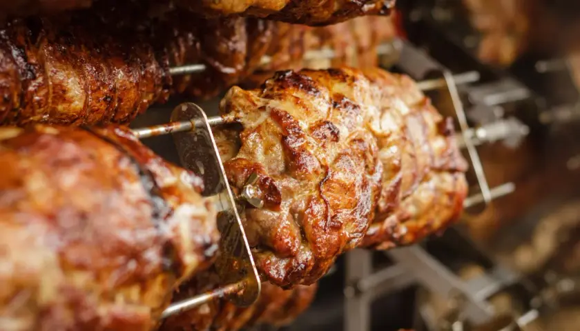 Cochon de lait grillé sur une rôtissoire. Quel vin avec cochon de lait grillé ? Un rouge fruité et léger serait parfait.