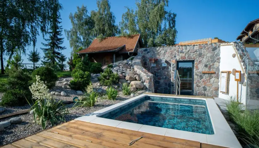 Relaks w lubuskim spa: basen, kamienna ściana z sauną i urokliwy ogród. Idealne miejsce na odpoczynek.