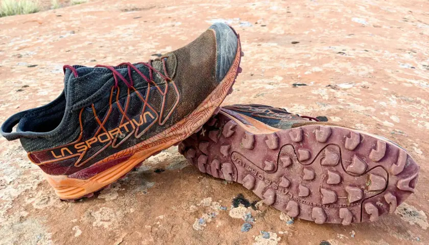 Trail running shoes with synthetic uppers, showing dirt and wear from a rugged adventure. Synthetic uppers are man-made materials, offering durability and water resistance.