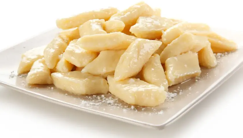 Pyszne leniwe pierogi na talerzu. Idealne co na obiad dla dzieci, posypane cukrem pudrem.